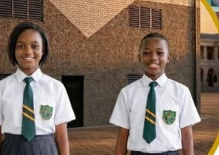 Deux élèves du collège en uniforme devant l’établissement.